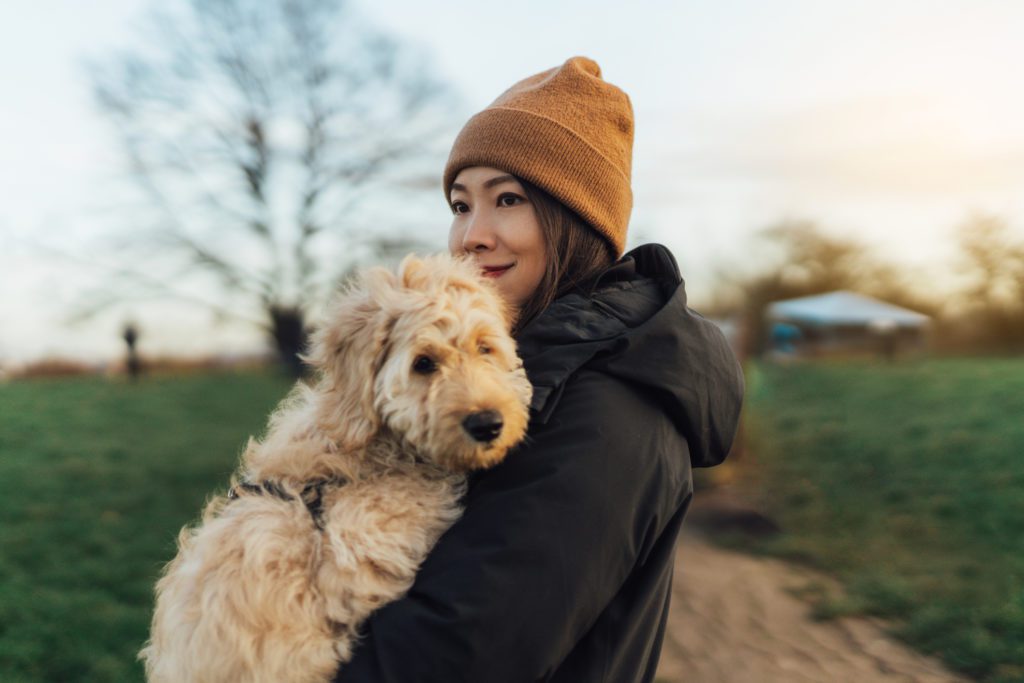 Young woman embracing her dog at the park