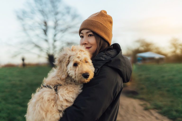 Young woman embracing her dog at the park