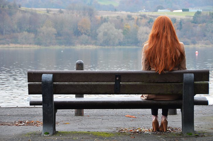 Rear view of woman sitting on bench